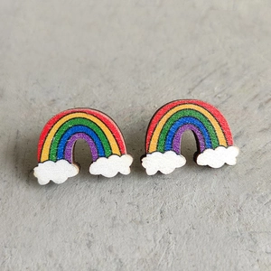 Gros plan sur les boucles d'oreilles arc-en-ciel en bois avec petits nuages blancs