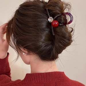 Pince à cheveux en acrylique avec perles rouges pour cheveux épais portée par modèle