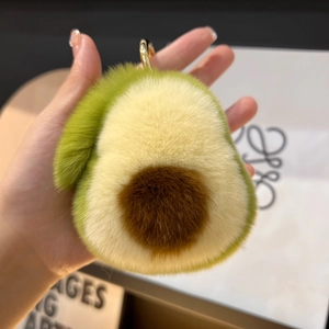 Dettaglio del portachiavi a forma di avocado in morbido peluche verde con gancio dorato