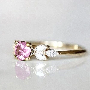 Detailed close-up of a gold ring with pink round stone and marquise accents