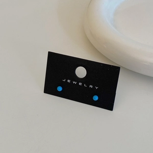 Detailed close-up of blue bead stud earrings on a jewelry card with a 45-degree angle view