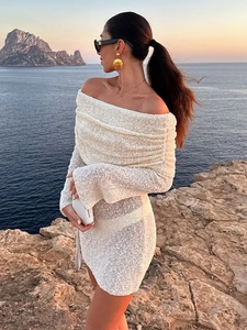 Elegant white off-the-shoulder knit mini dress worn by a model on a sunset beach