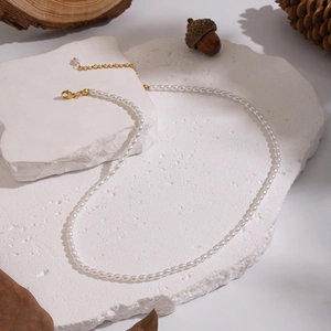 Dettaglio di una collana di perle fatta a mano con chiusura dorata su pietre
