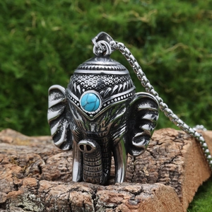 Détail d'un pendentif éléphant exotique avec incrustation de turquoise sur bois
