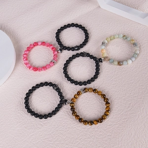 Detail shot of magnetic beaded bracelets with crown charms and natural stone textures