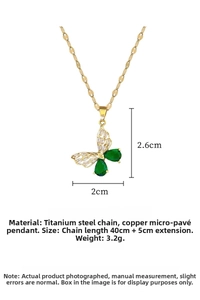 Detailed view of hollow butterfly pendant necklace with green gems and white crystals