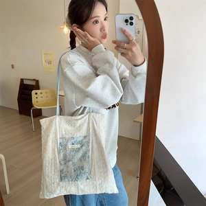 Lace tote bag with vintage blue floral pocket shown in a lifestyle mirror selfie