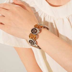 Détail d'un bracelet vintage avec étoiles en émail et incrustations géométriques ambre