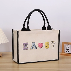 Close-up of canvas tote bag with easy letter embroidery and pink heart detail