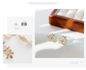 Detail of small daisy stud earrings with sparkling crystal petals and golden center