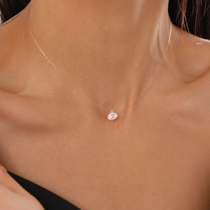 Close-up of invisible fish line necklace featuring a single round zircon pendant on neck