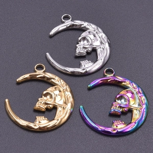 Detailed view of moon skull pendants in silver, gold, and iridescent finishes