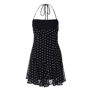 Detail of a chic black polka dot halter dress featuring waist tie and lightweight fabric