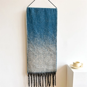 Detailed view of the thick blue-grey gradient scarf with decorative soft fringe tassels