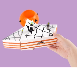 Detail of triangle cake-shaped Halloween candy box with spider web patterns and candle topper