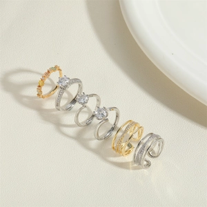 Detail of 14K gold and silver plated rings with zircon stones in floral and pave styles