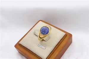 Close-up of golden signet ring with round blue lapis lazuli stone on jewelry display