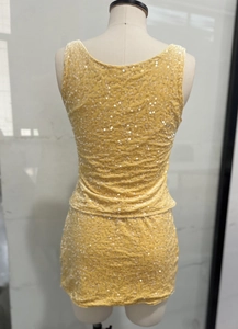 Detail of yellow sequin two-piece set featuring back view of crop top and mini skirt