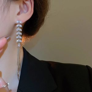 Detail of silver tassel earrings with zircon wheat leaves worn by a female model