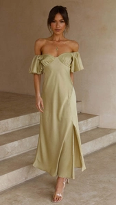 Détail d'une élégante robe satinée vert clair avec épaules nues et fente latérale