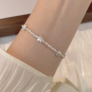 Elegante zilveren vlinderbedelarmband voor dames in een minimalistische luxe stijl aan de pols