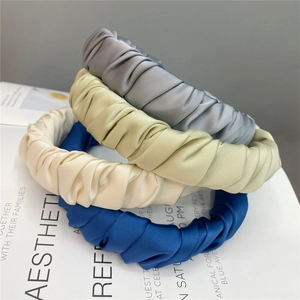 Set of four satin pleated headbands in grey, green, cream, and navy on aesthetic background