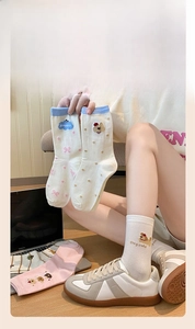 Detail of cream cotton socks with cute cartoon dog embroidery and soft blue ribbed cuffs