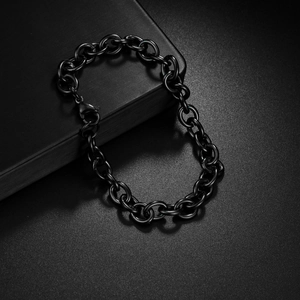 Bracelet à maillons en O en acier titane noir poli sur un fond texturé de couleur sombre