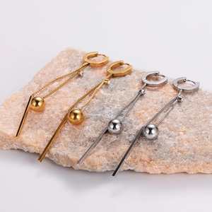 Detail of long tassel drop earrings with metal beads and bars in gold and silver finish