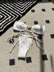 Detail of white ribbed bikini with golden starfish hardware and side-tie bottom