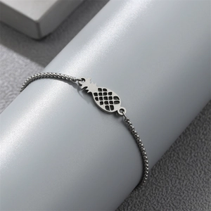 Macro view of silver stainless steel bead chain bracelet featuring a hollow pineapple charm