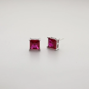 Close-up of square red zircon stud earrings with silver four-prong setting