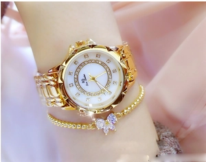 Close-up of gold ladies watch with floral dial and matching butterfly bracelet