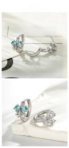 Détail de créoles papillon en argent avec des zircons en forme de cœur bleu clair