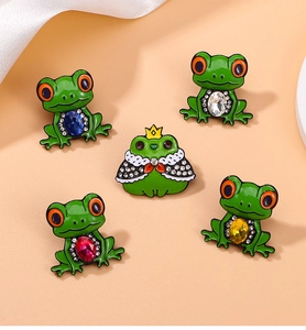 Detailed set of five cartoon frog pins with colorful rhinestones and green enamel finish