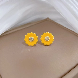 Close-up of luxury yellow sunflower earrings with clear crystals and gold plating