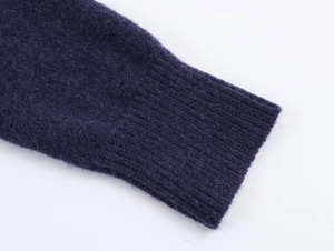 Vue macro des poignets en tricot côtelé bleu foncé d'une veste à capuche vintage chic