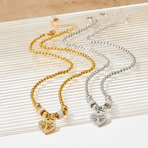 Gold and silver heart tree of life necklaces with sparkling rhinestones on textured glass