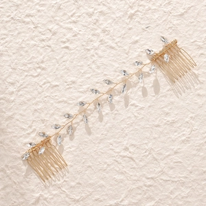 Close-up of golden bridal hair vine with crystal leaves and secure metal side combs