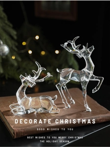 Detail of clear acrylic Christmas reindeer figurines set on vintage books with bokeh lights
