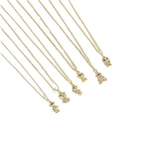 Golden bear pendant necklaces with shimmering black and white crystal inlay on white background