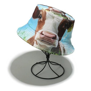 Macro detail of cow print bucket hat featuring realistic animal face and yellow ear tag