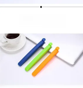Three colorful plastic food sealing clips in blue, green and orange on an office desk