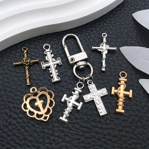 Detailoverzicht van metalen kruis- en hartvormige bedeltjes voor DIY sieraden