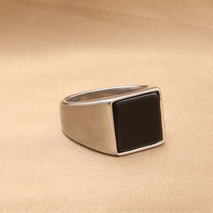 Macro shot of square black stone inlay on silver stainless steel vintage signet ring