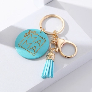 Detail view of a blue wooden Mother's Day keychain with gold MAMA text and a blue tassel