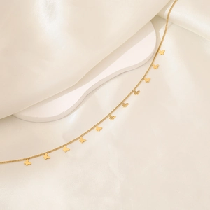 Detailed close-up of a gold stainless steel butterfly pendant necklace on silk