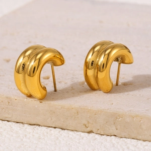 Double-layered C-shaped gold-plated stainless steel stud earrings on a textured stone base