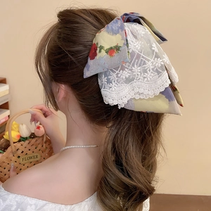 Detail of floral lace bow hair claw clip showing vintage texture on ponytail