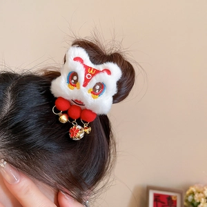 Détail macro de la pince à cheveux lion en peluche blanche avec pompons et clochettes